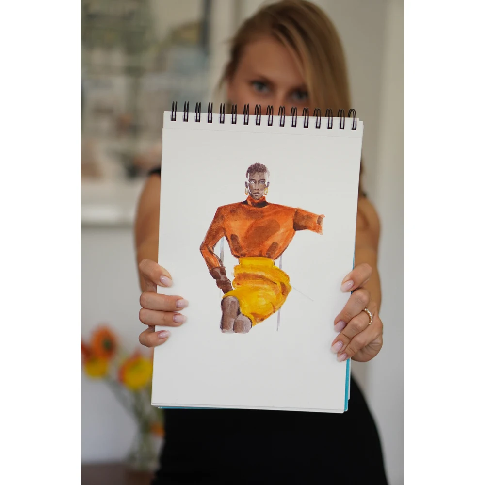 Oksana holding Golden Geometry, an amber and gold fashion watercolor